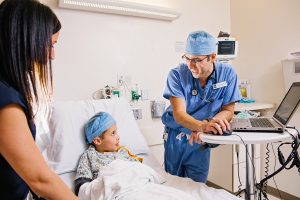 photography of kalamazoo anesthesiology doctor talking to a child in a hosptal bed